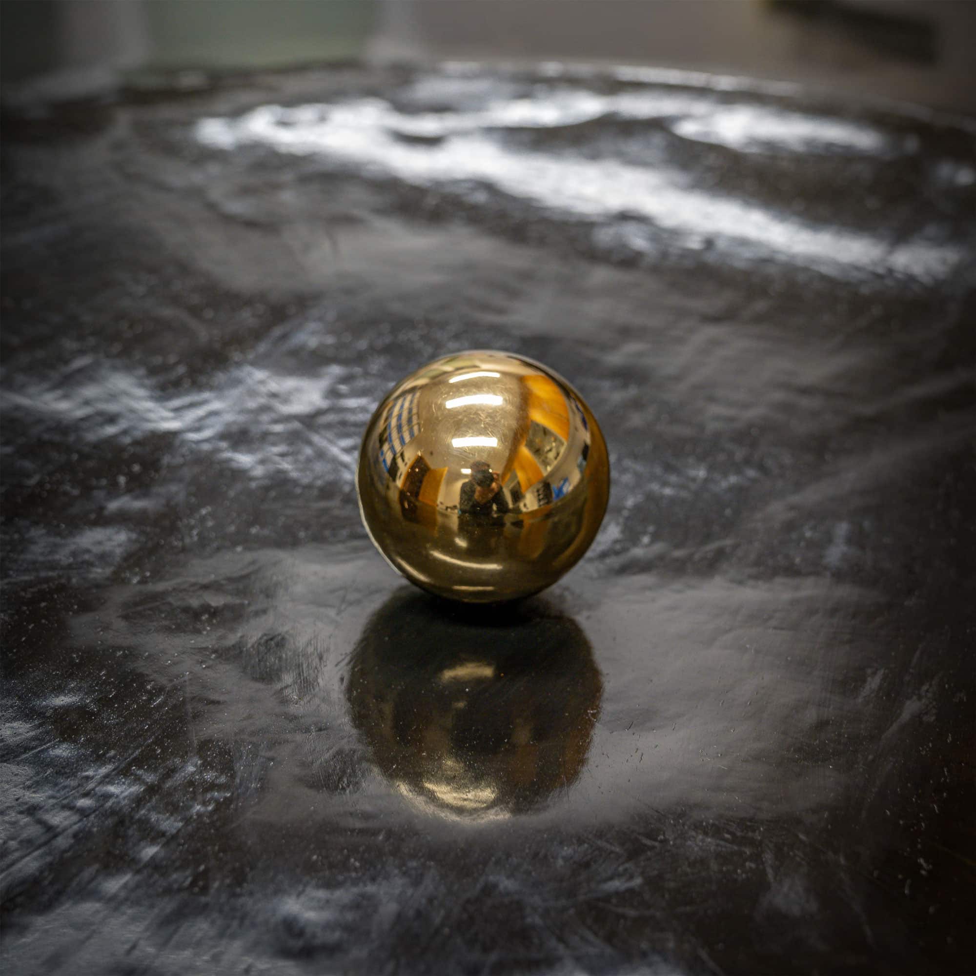 Kunstwerk mit dem Namen „Manipura“. Kugel 24 Karat vergoldet, Rahmen Metall, Bild Metall schwarz brüniert. Vom Stahlbildhauer im Atelier Daniel Springer